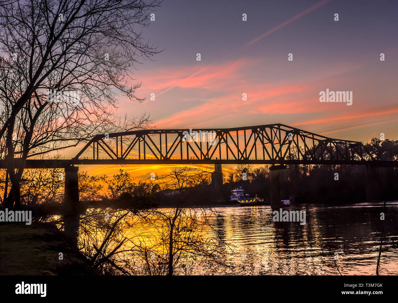 The sun sets on the M&O Railroad trestle, viewed from the Tuscaloosa Riverwalk, March 18, 2014, in Tuscaloosa, Alabama. Stock Photo