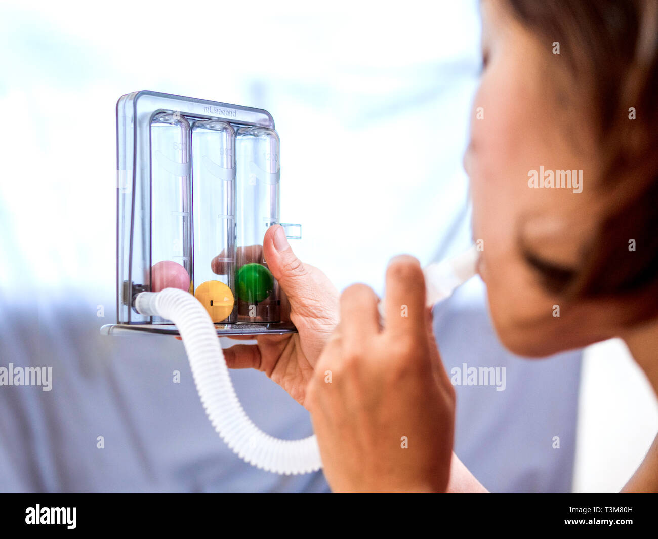 woman holding triflow and deep breathing to improve lung expansion