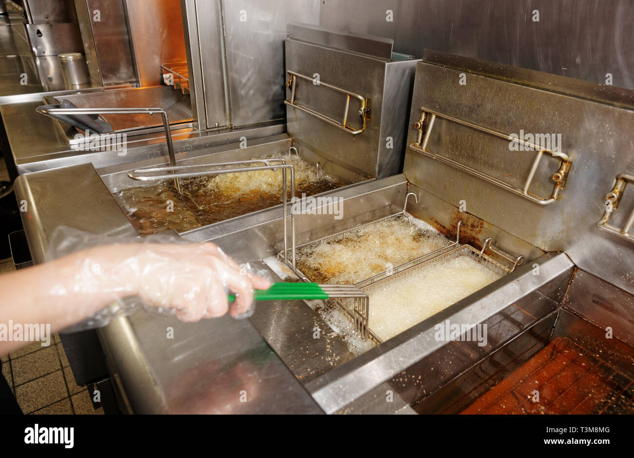 Deep fryers with boiling oil on fast food kitchen Stock Photo Alamy