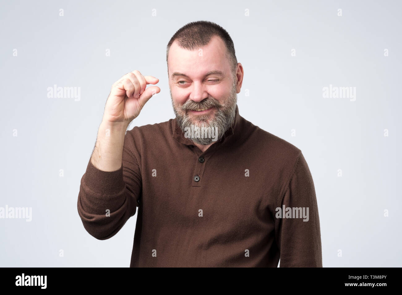 Mature caucasian man gesturing with hand showing small size Stock Photo