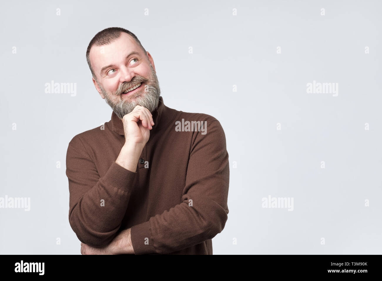 Mature bearded man looking up and thinking about future. Stock Photo