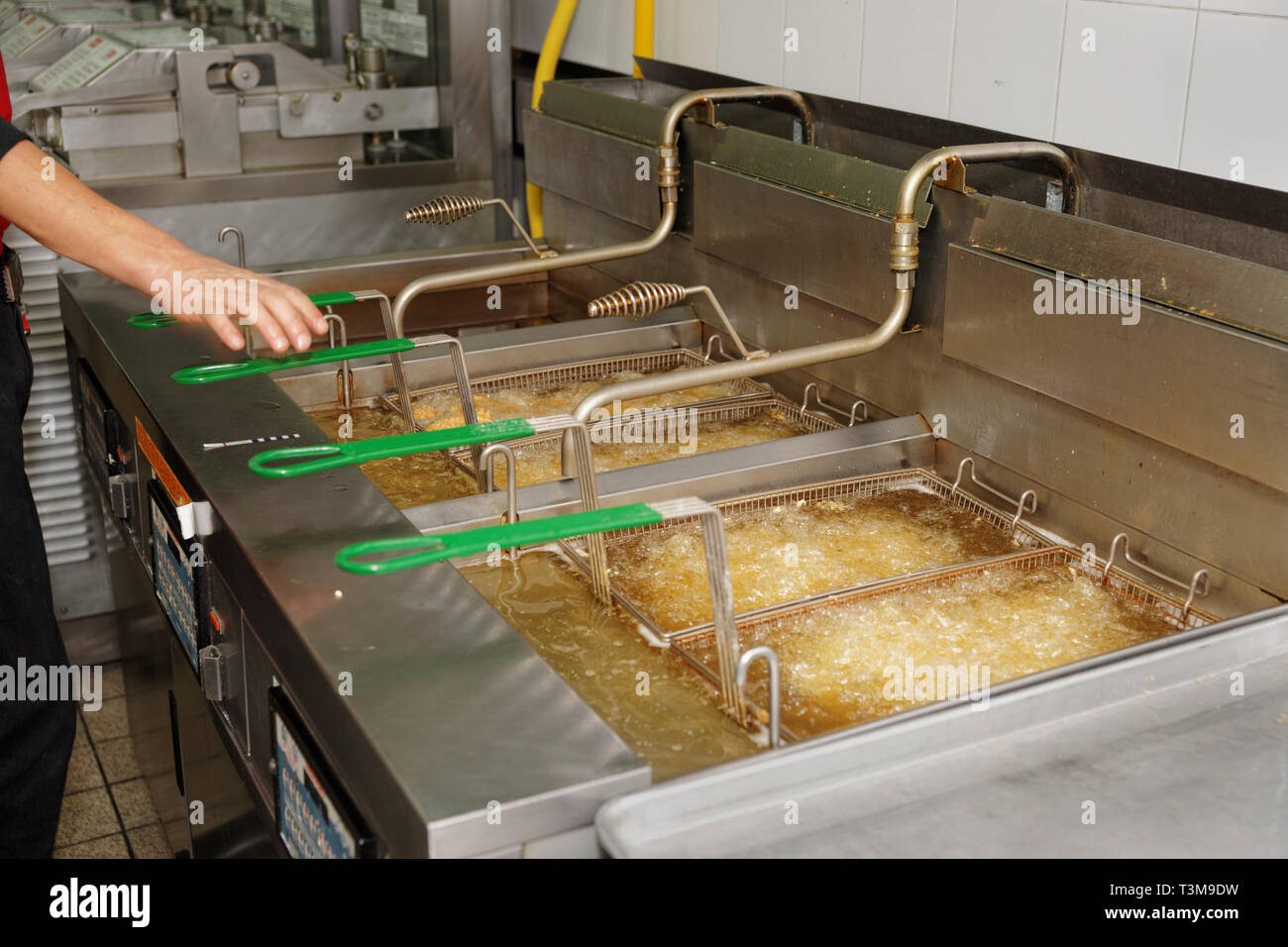Deep fryers with boiling oil on fast food kitchen Stock Photo Alamy