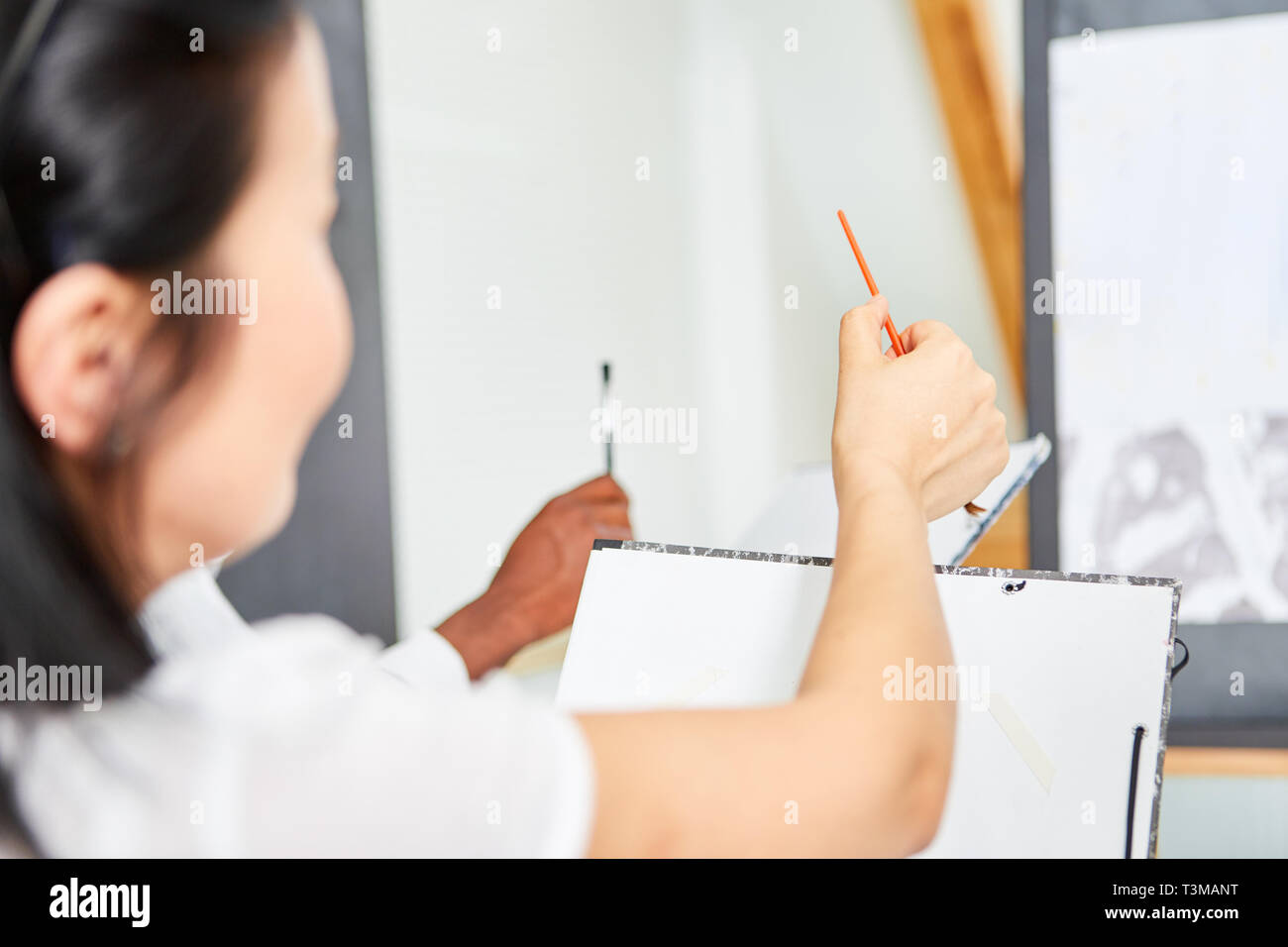 Woman as a beginner or art student learns painting in a course at the community college Stock Photo