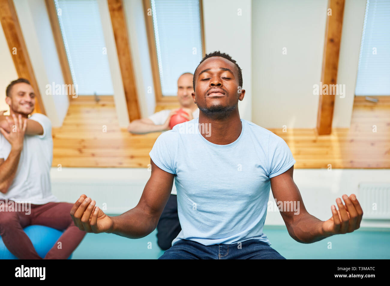 African man doing a breathing exercise while doing yoga for rest and relaxation Stock Photo