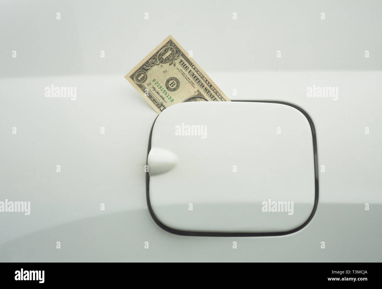 dollar bill. money in the fuel tank concept of expensive gas Stock Photo