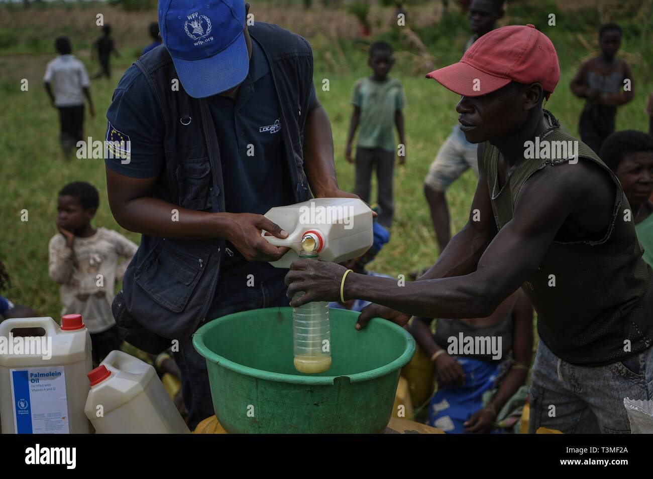 A World Food Programme worker distributes food aid to local residents in the aftermath of the massive Cyclone Idai April 8, 2019 in Bebedo, Mozambique. The World Food Programme, with help from the U.S. Air Force is transporting emergency relief supplies to assist the devastated region. Stock Photo