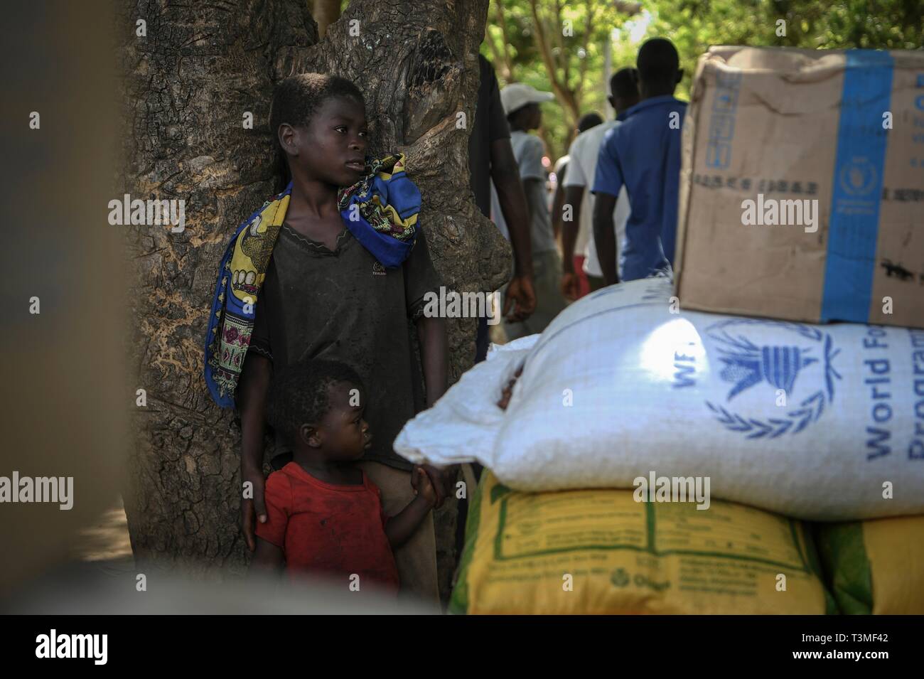 Mozambican children wait for food aid distribution in the aftermath of the massive Cyclone Idai April 8, 2019 near Bebedo, Mozambique. The World Food Programme, with help from the U.S. Air Force is transporting emergency relief supplies to assist the devastated region. Stock Photo