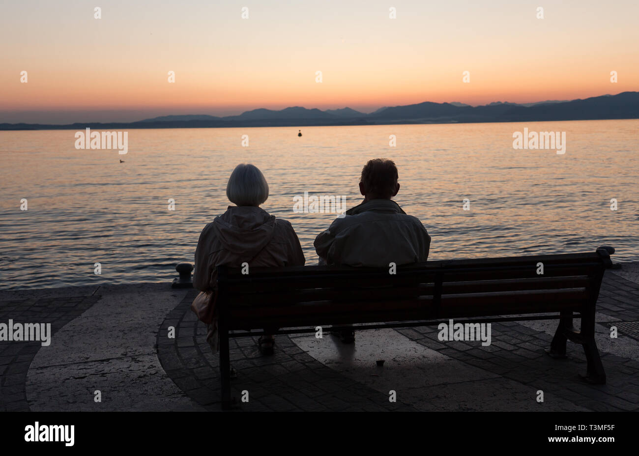 Man on bench lake como hi-res stock photography and images - Alamy