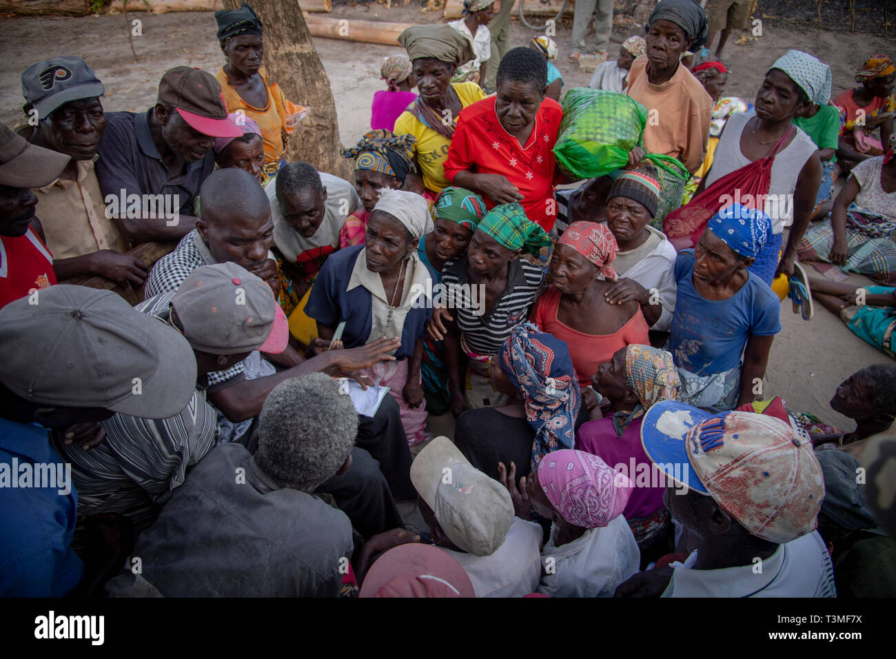 Village elders wait for food aid to be distributed in the aftermath of the massive Cyclone Idai April 6, 2019 in Nhagau, Mozambique. The World Food Programme, with help from the U.S. Air Force is transporting emergency relief supplies to assist the devastated region. Stock Photo