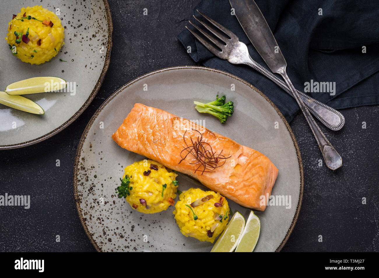 Grilled Salmon Fillet with Saffron Risotto on Dark Background Stock Photo