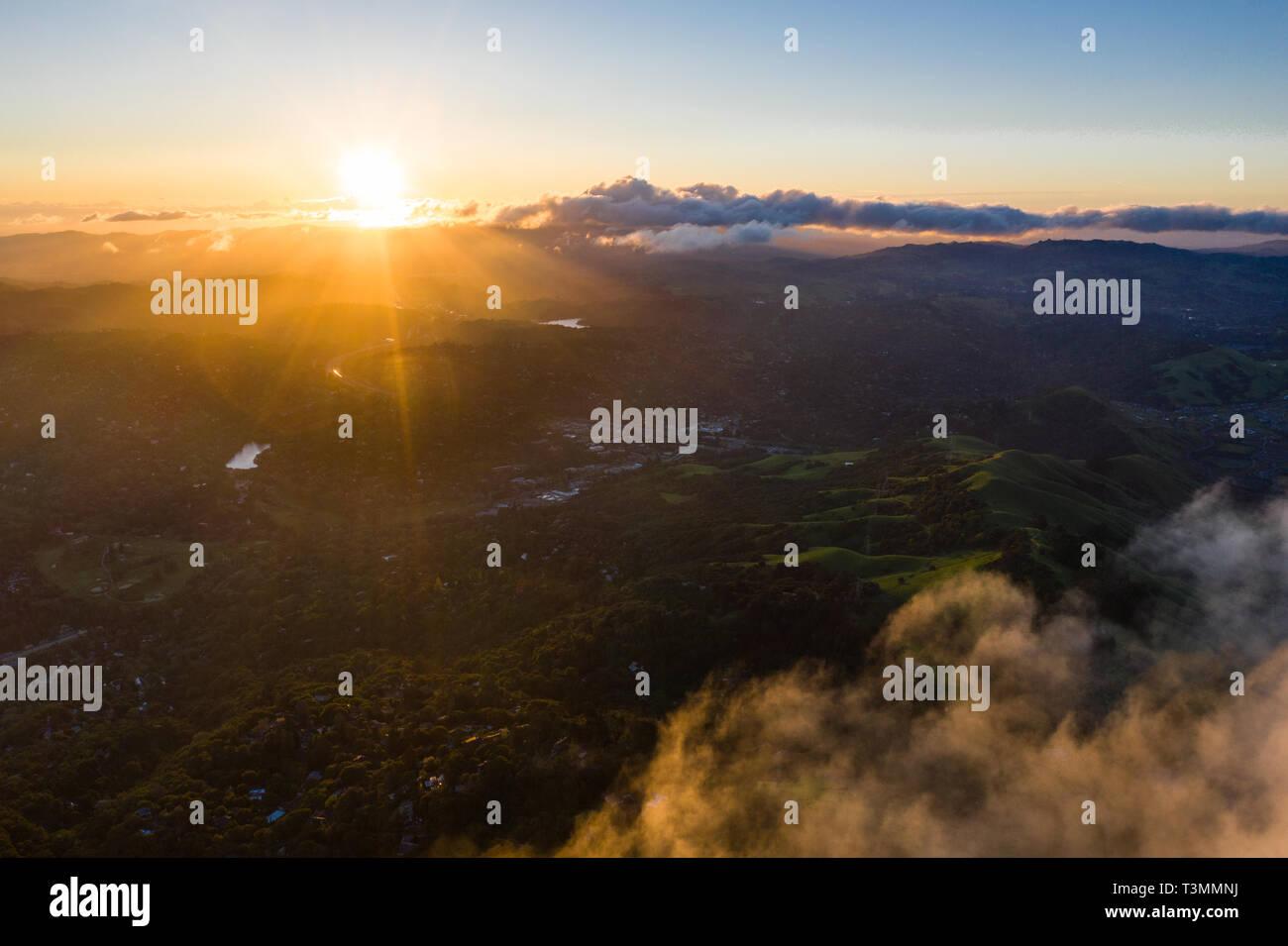 A beautiful sunrise illuminates the hills surrounding San Francisco Bay in Northern California. This area is often covered by a thick marine layer. Stock Photo