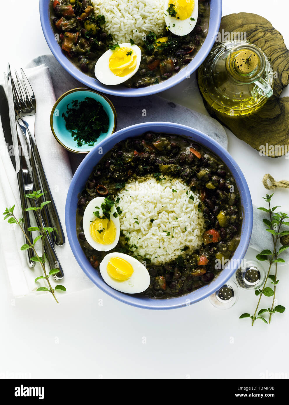 rice with black beans and boiled egg on the table with spices and olive