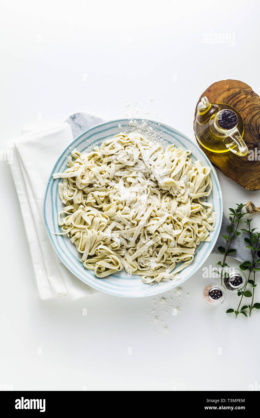 Fresh homemade tagliatelle pasta ready to be cooked. on a white table ...
