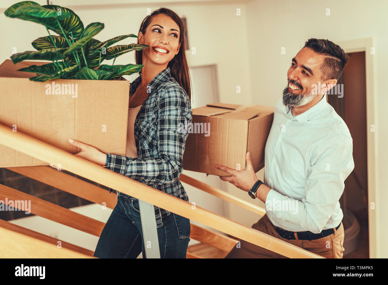 The young happy couple is moving into a new house. They bring boxes