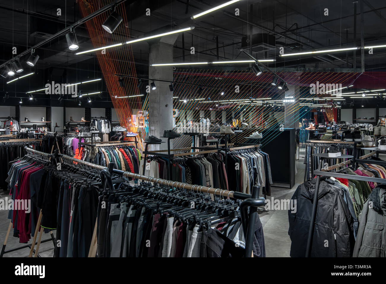 Modern clothes shop with large selection of different wear and shoes Stock Photo