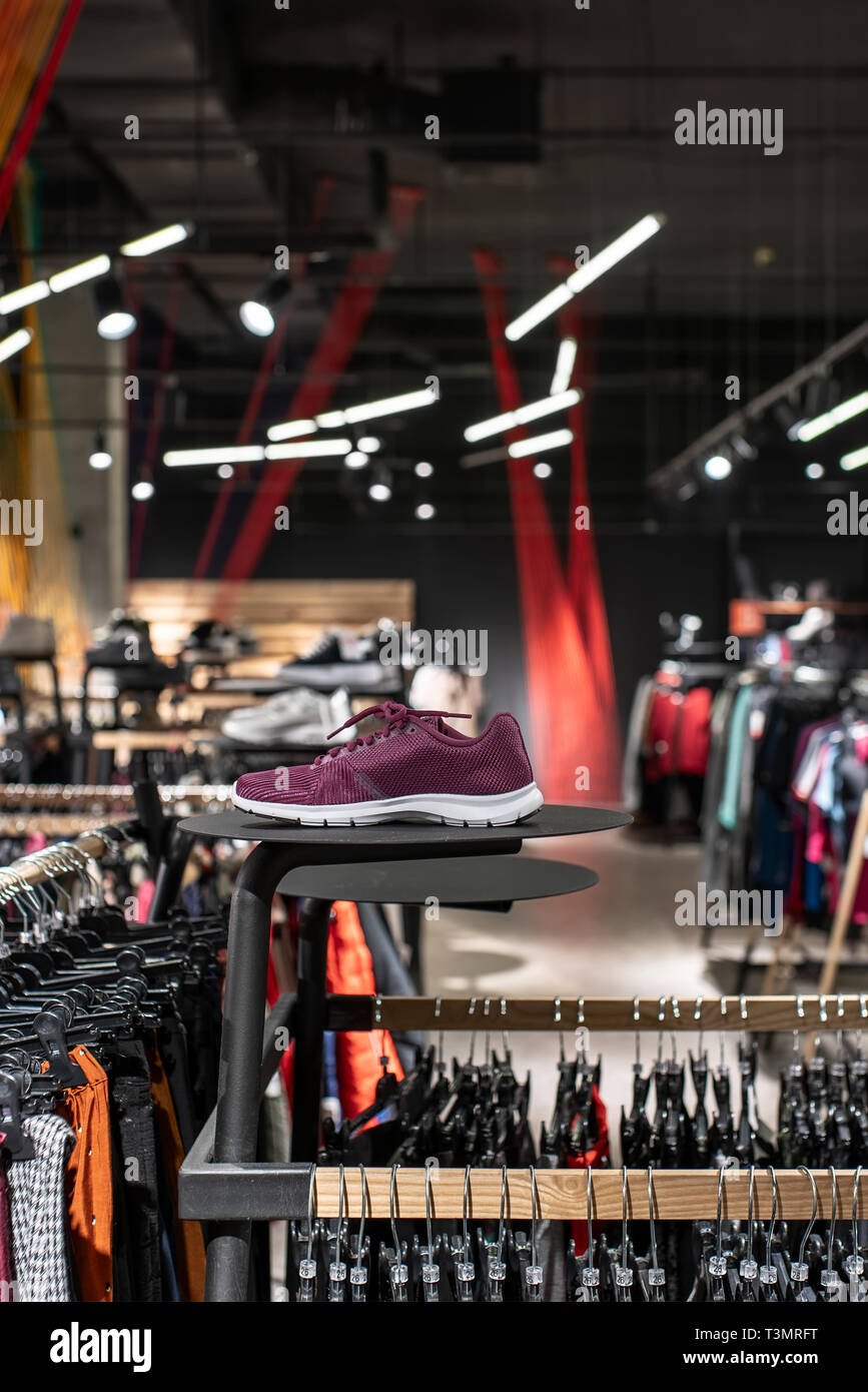 Modern clothes shop with large selection of different wear and shoes Stock Photo