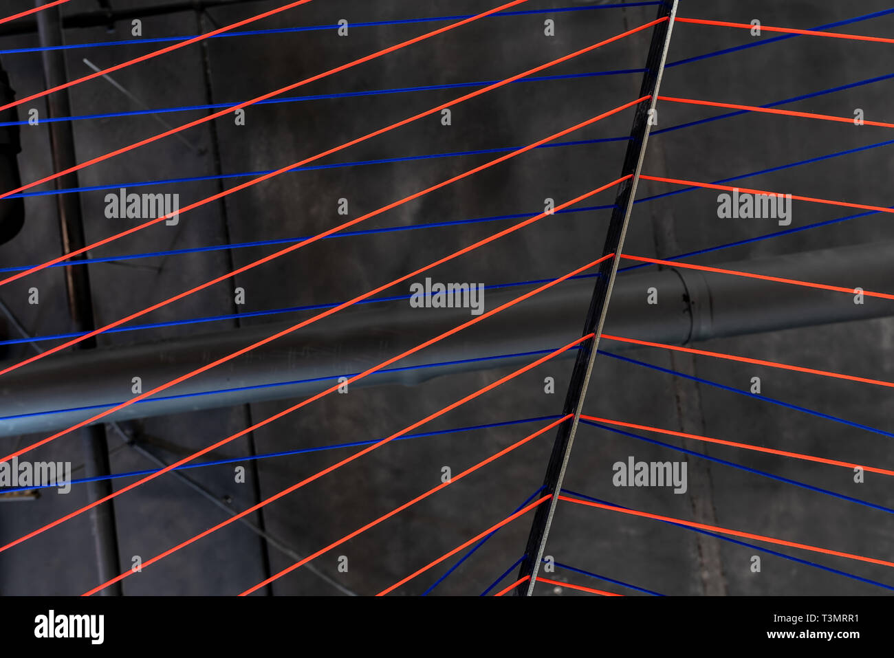 Multicolored ropes lines installation in illuminated interior Stock Photo