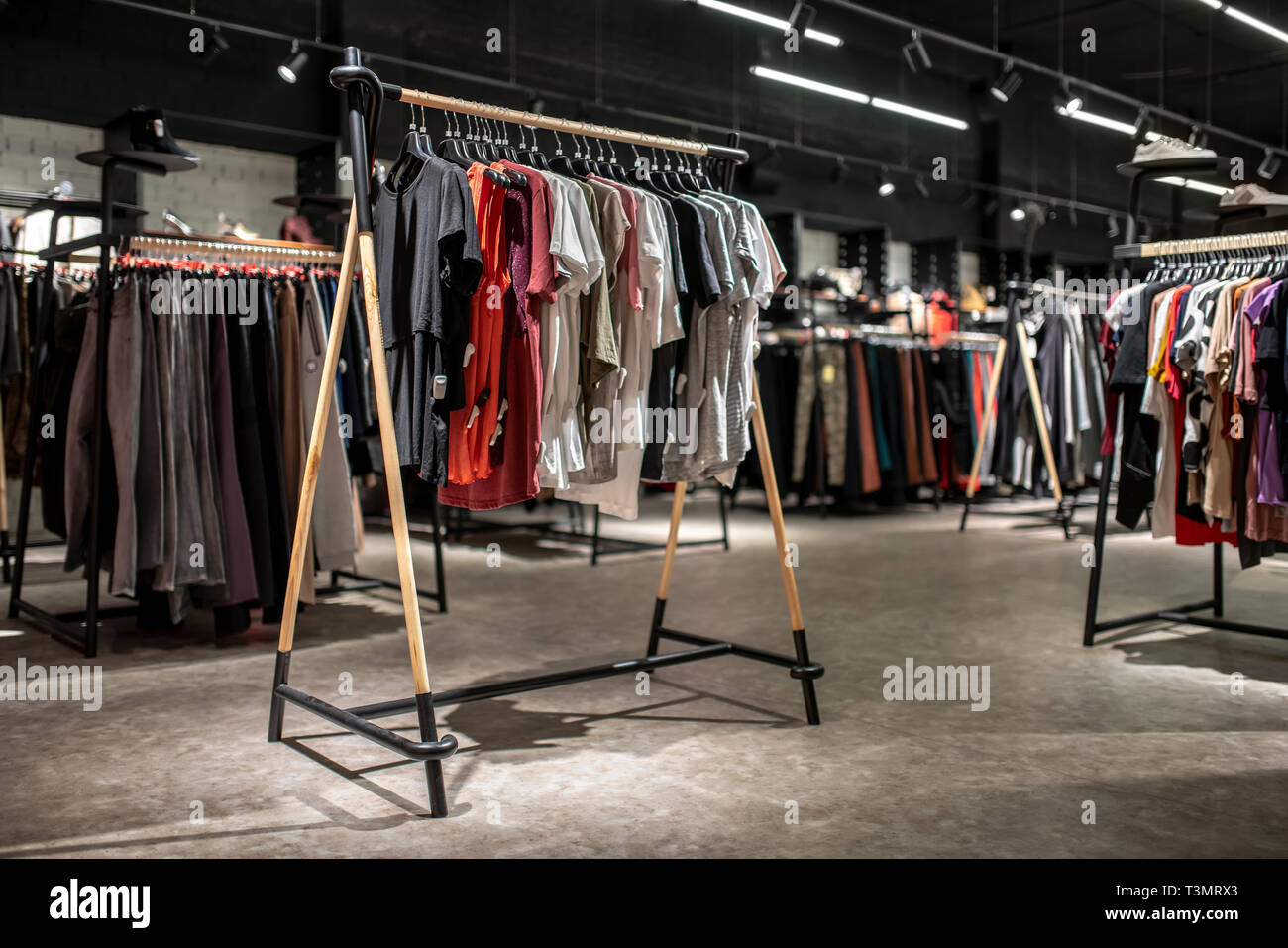 Modern clothes shop with large selection of different wear and shoes Stock Photo