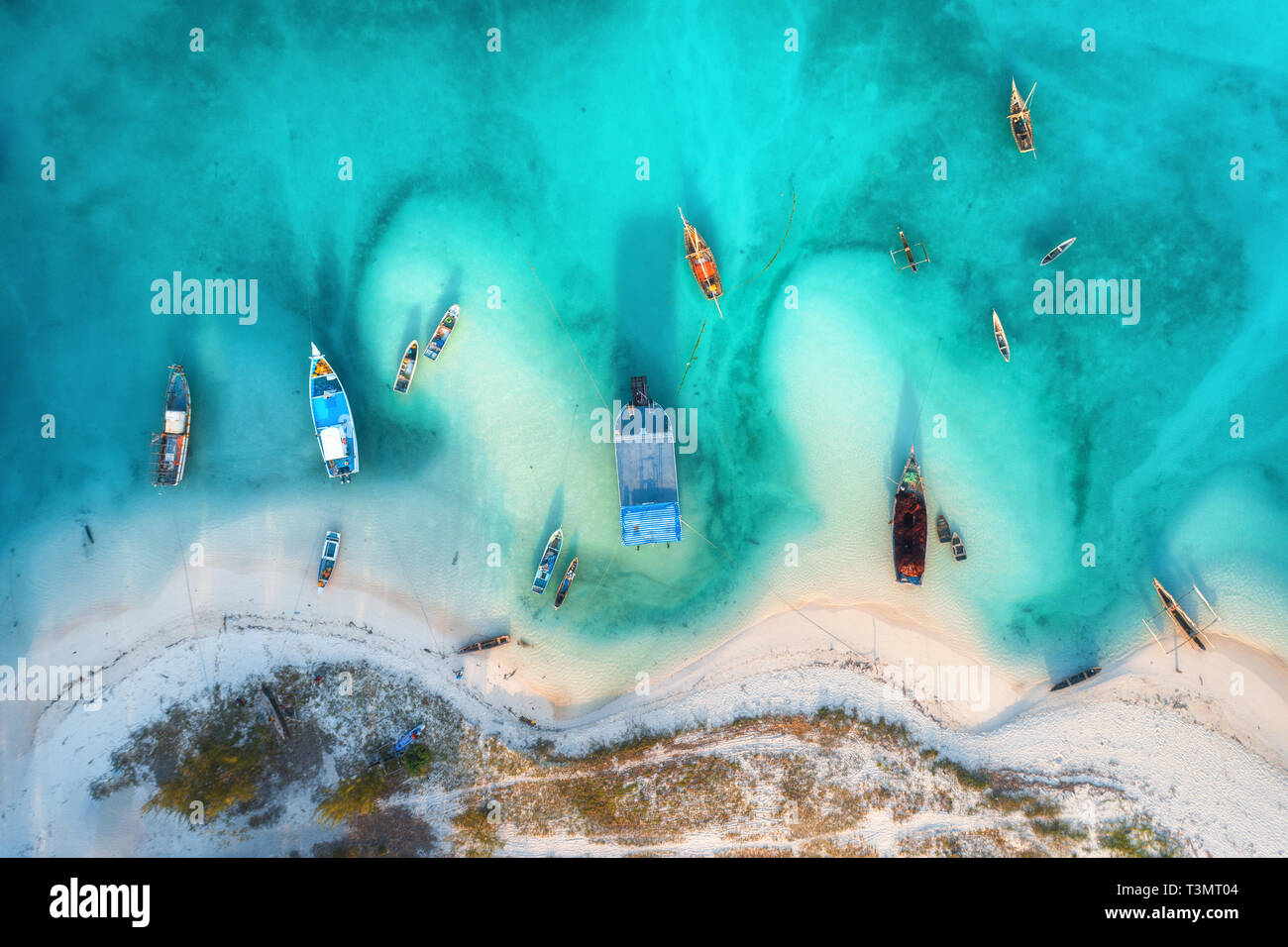 Aerial view of the fishing boats in clear azure water at sunset in ...