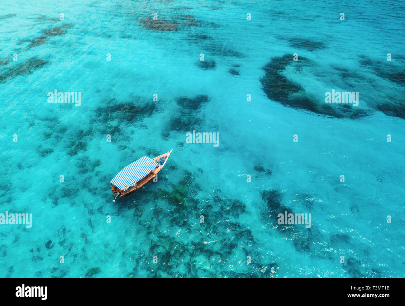 Aerial view of the fishing boat in clear blue water at sunny day in ...