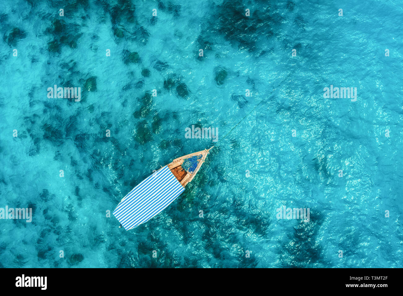 Aerial view of the fishing boat in clear blue water at sunny day in ...