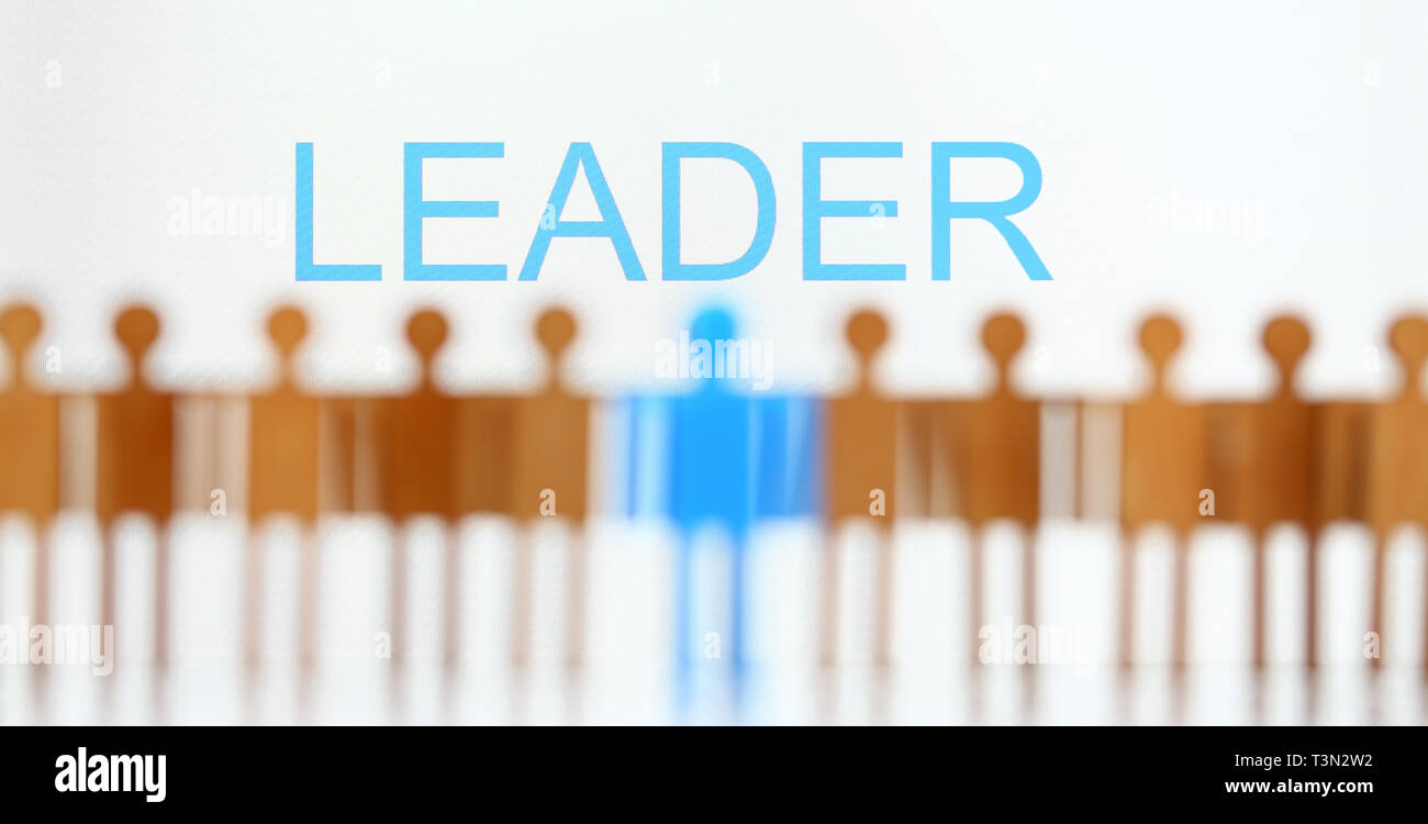 Line Up Leader Sign Leader sign above line of toy human figures Stock Photo - Alamy