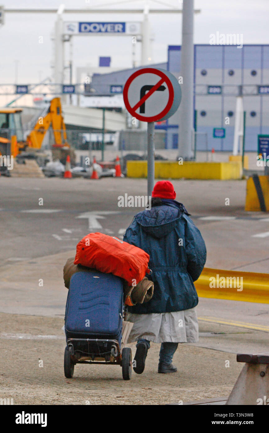 An asylum who is sleeping rough walks towards the port with his belongings. Dover, UK. 06/12/2005 Stock Photo