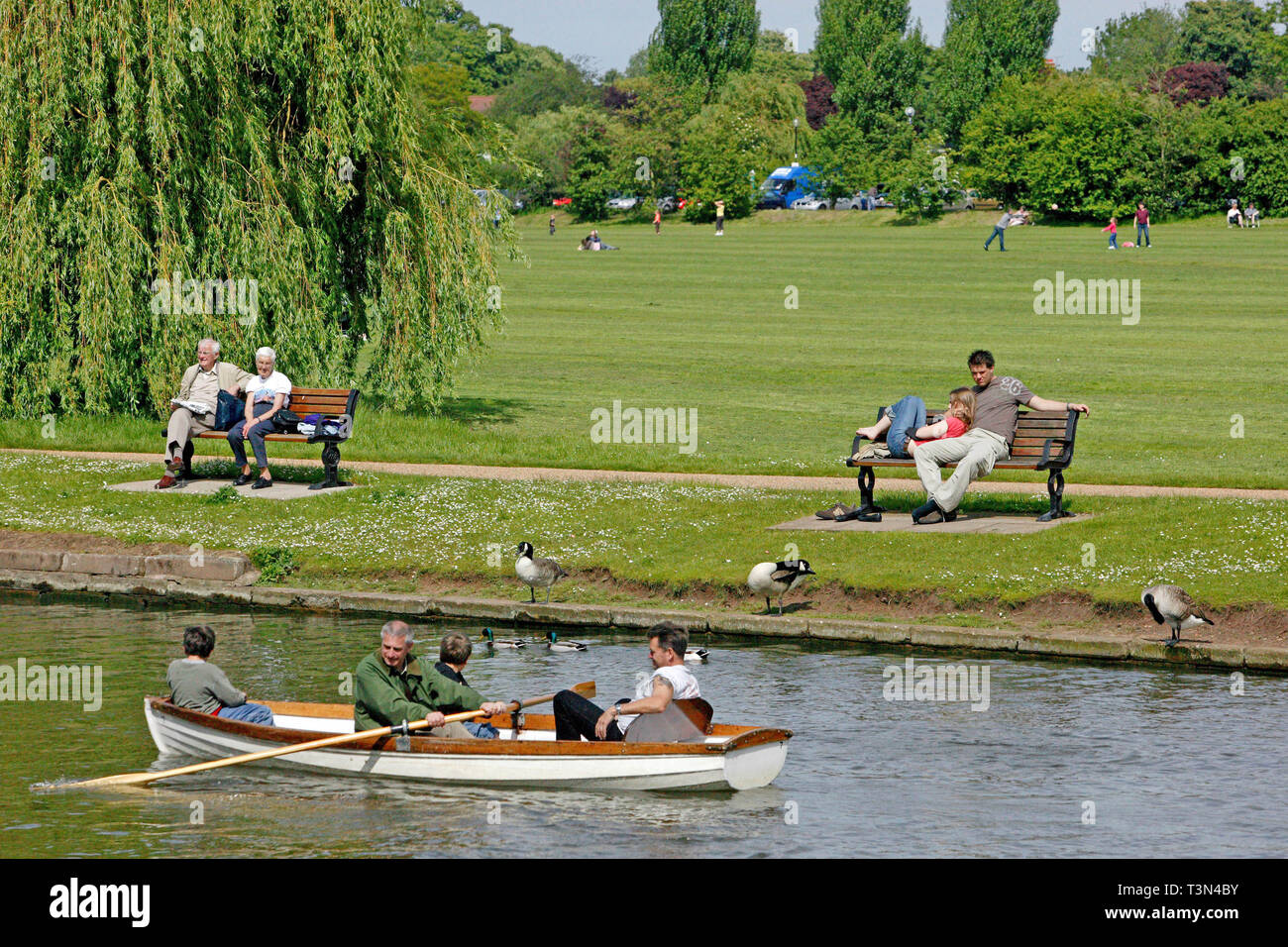 A family enjoying a day on the river in a rowing boat. The River Avon