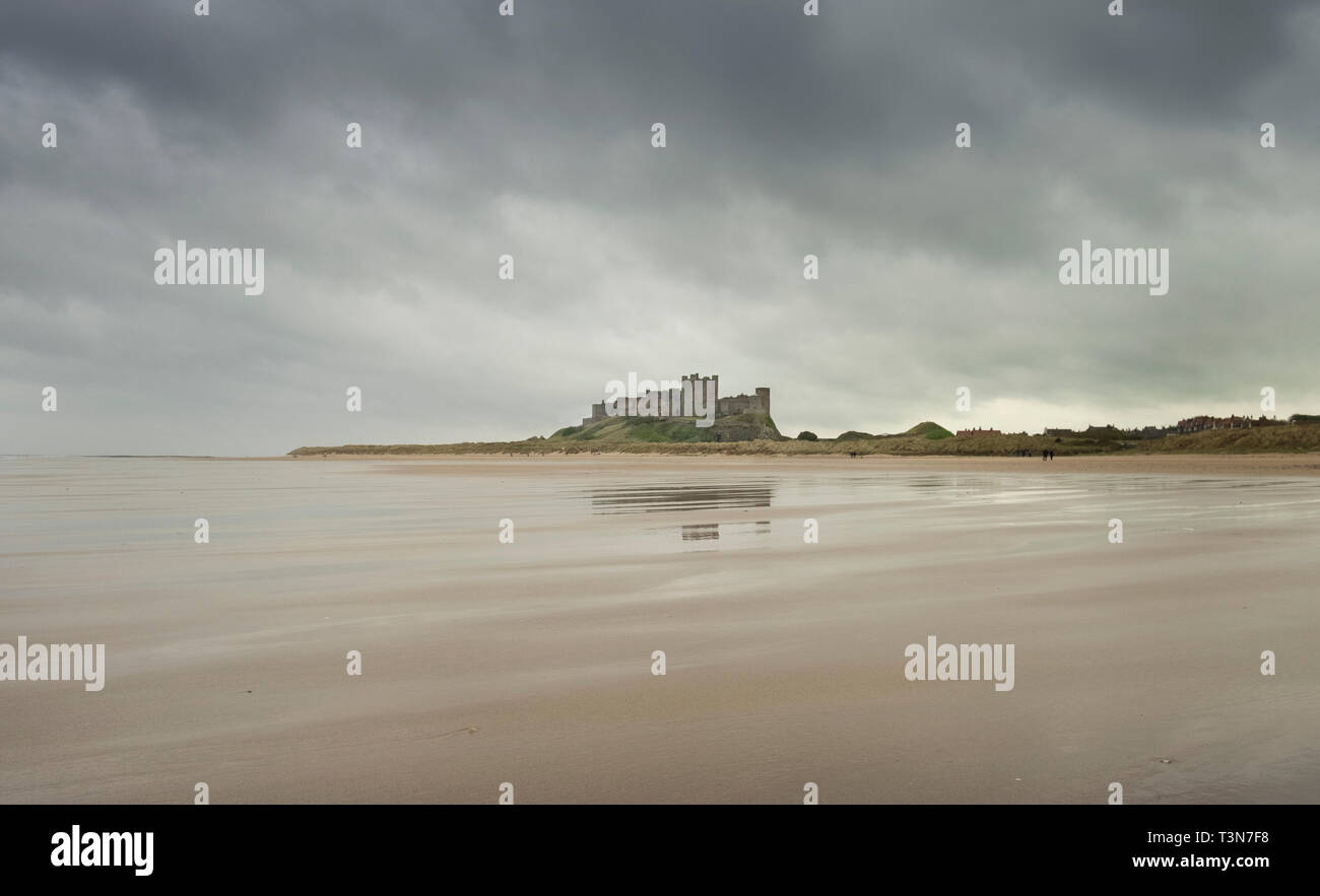 Bamburgh castle, brooding sky and beautiful empty beach, Northumberland ...