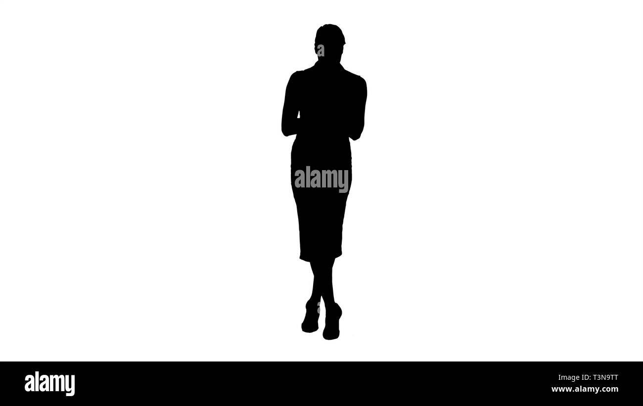 Silhouette Attractive european female with smartphone in hand, touching screen with finger to type message. Stock Photo