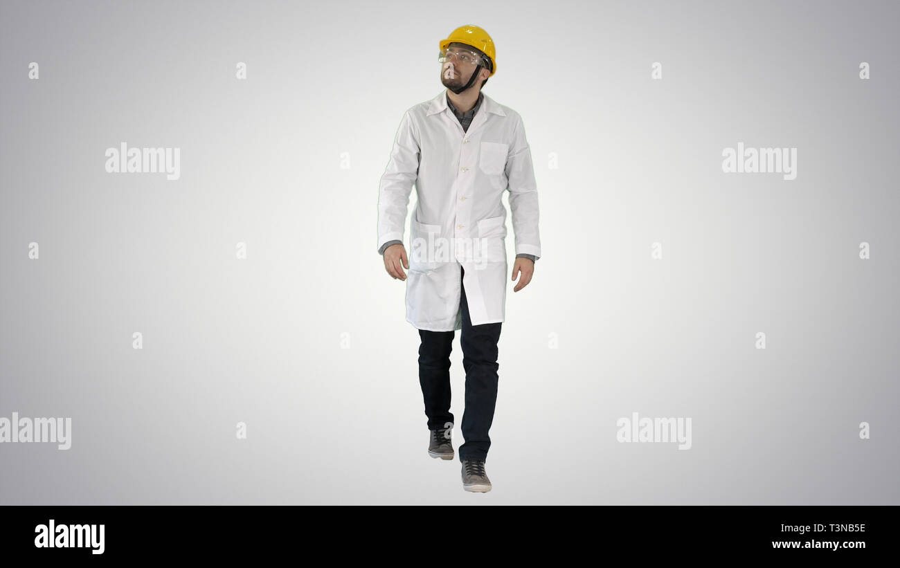 Engineer putting on protactive glasses while walking on gradient background. Stock Photo