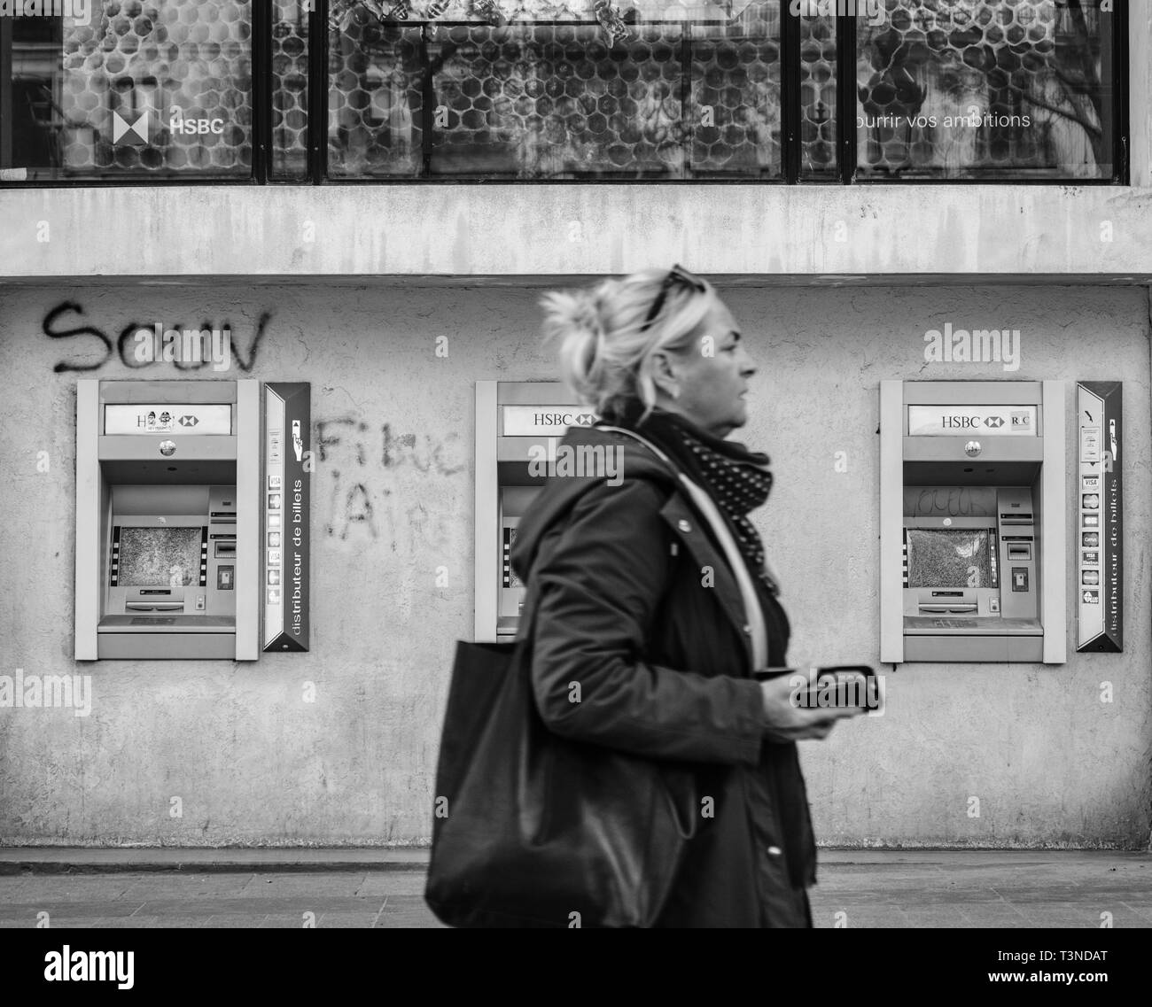 Paris, France - Mar 19, 2019: Pedestrians walking in front of Champs Elysee HSBC bank branch ATM bancomat vandalized after demonstrations by the Yellow Vests Gilets Jaunes movement  Stock Photo
