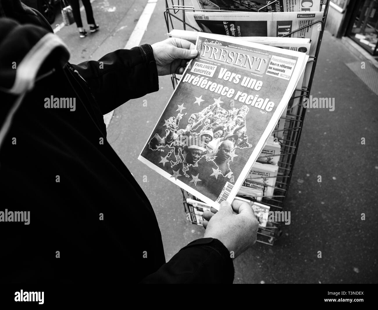 Paris, France - 29 Mar 2019: Newspaper stand kiosk selling press with senior male hand buying latest Quotidien Present featuring  European Elections on front cover with prefered racial election black and white Stock Photo
