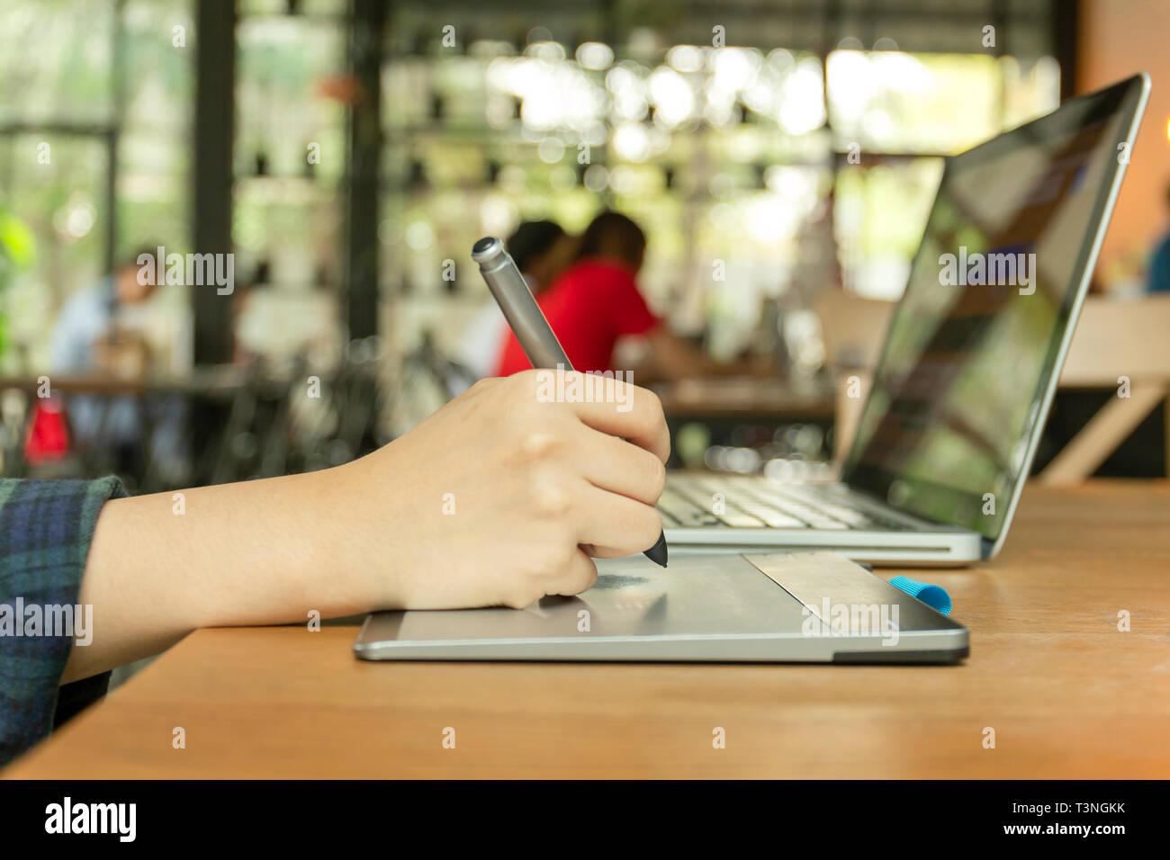 Hand using digital tablet and stylus penand working on laptop computer Stock Photo Alamy