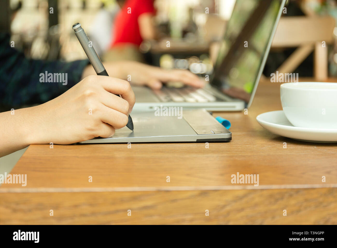 Hand using digital tablet and stylus penand working with laptop computer Stock Photo Alamy