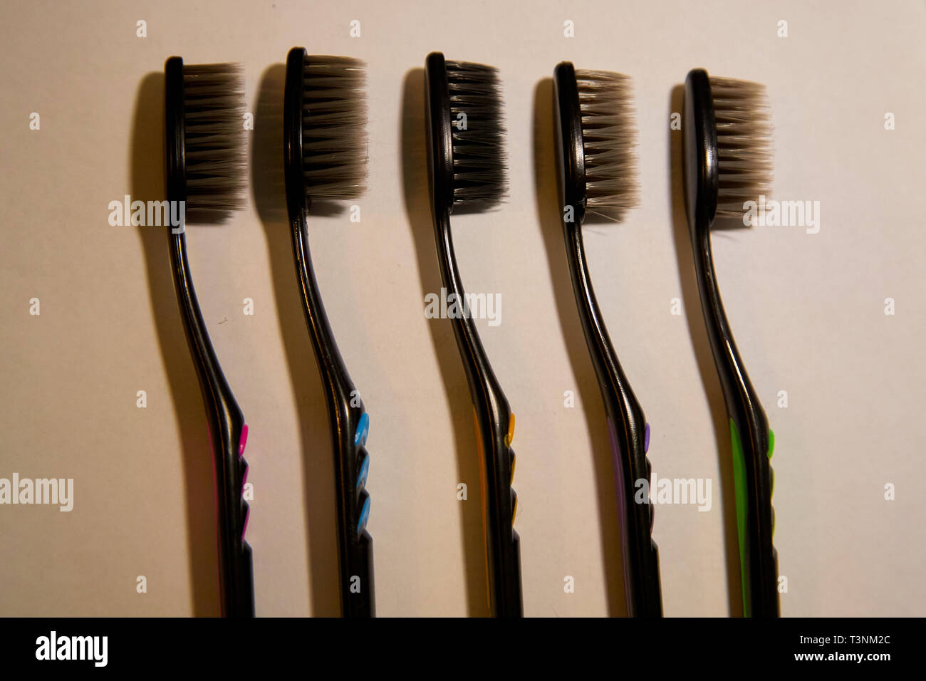 Colorful toothbrush with black bristles on white background. Five ...