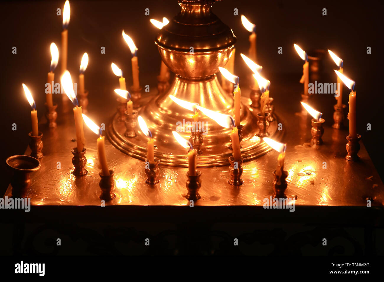 Christianity church interior. Set of lighting candles on dark