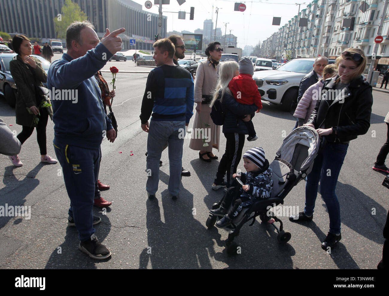 A man seen shouting slogans while a baby watches during the demonstration. Protesters with their children demonstrate demanding to stop the violation of children's rights by Kiev's developer companies. Stock Photo