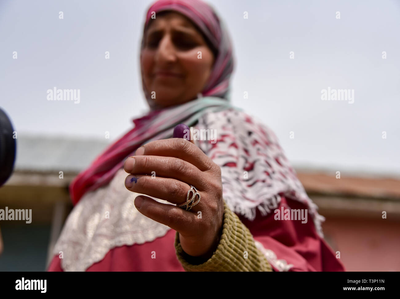 Baramulla, Jammu and Kashmir, India. 11th Apr, 2019. A Kashmiri voter seen showing an ink mark on her finger after casting a vote outside polling station at Shadipora.Voting began for two parliamentary seats in the Indian Kashmir amid tight security and a boycott call by separatists. Armed police and paramilitary soldiers in riot gears guarded polling stations and nearby roads. Credit: Idrees Abbas/SOPA Images/ZUMA Wire/Alamy Live News Stock Photo