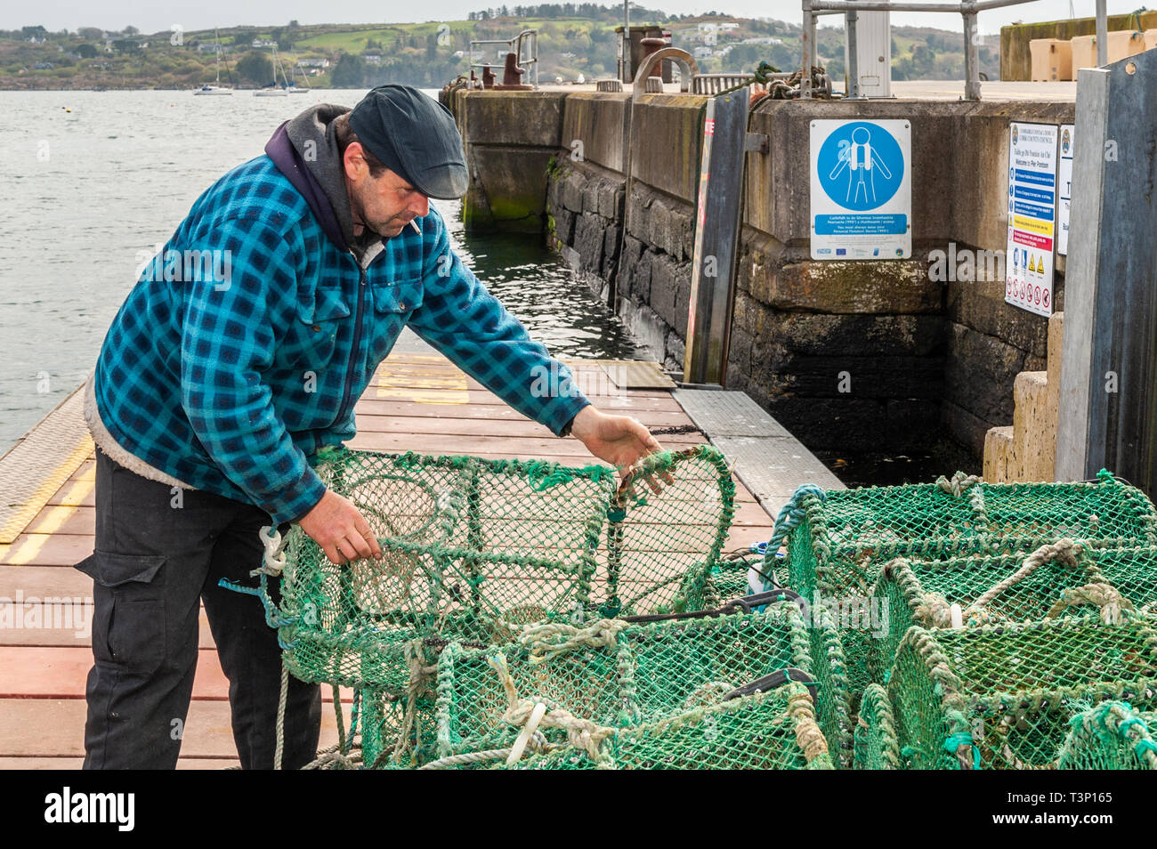 Schull, West Cork, Ireland. 11th Apr, 2019. A local fisherman prepares his crab pots before loading them onto his boat for a fishing trip later today. The weather is cold but dry with the sun starting to make an appearance. The day will remain mostly dry with top temperatures of 11 to 15°C. Credit: Andy Gibson/Alamy Live News Stock Photo