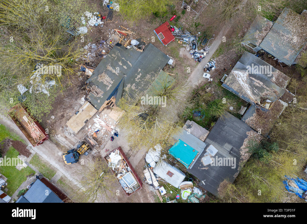 North Rhine-Westphalia, Lügde, Germany. 11 April 2019. An excavator stands in front of the partly demolished plot of land of the alleged perpetrator at the camping site Eichwald in the district Elbrinxen and demolishes the complete complex. (Recorded with a drone). The campsite operator has the crime scene demolished, where several children were abused and filmed. The demolition work will continue until the weekend due to the large quantity. Photo: Guido Kirchner/dpa Stock Photo