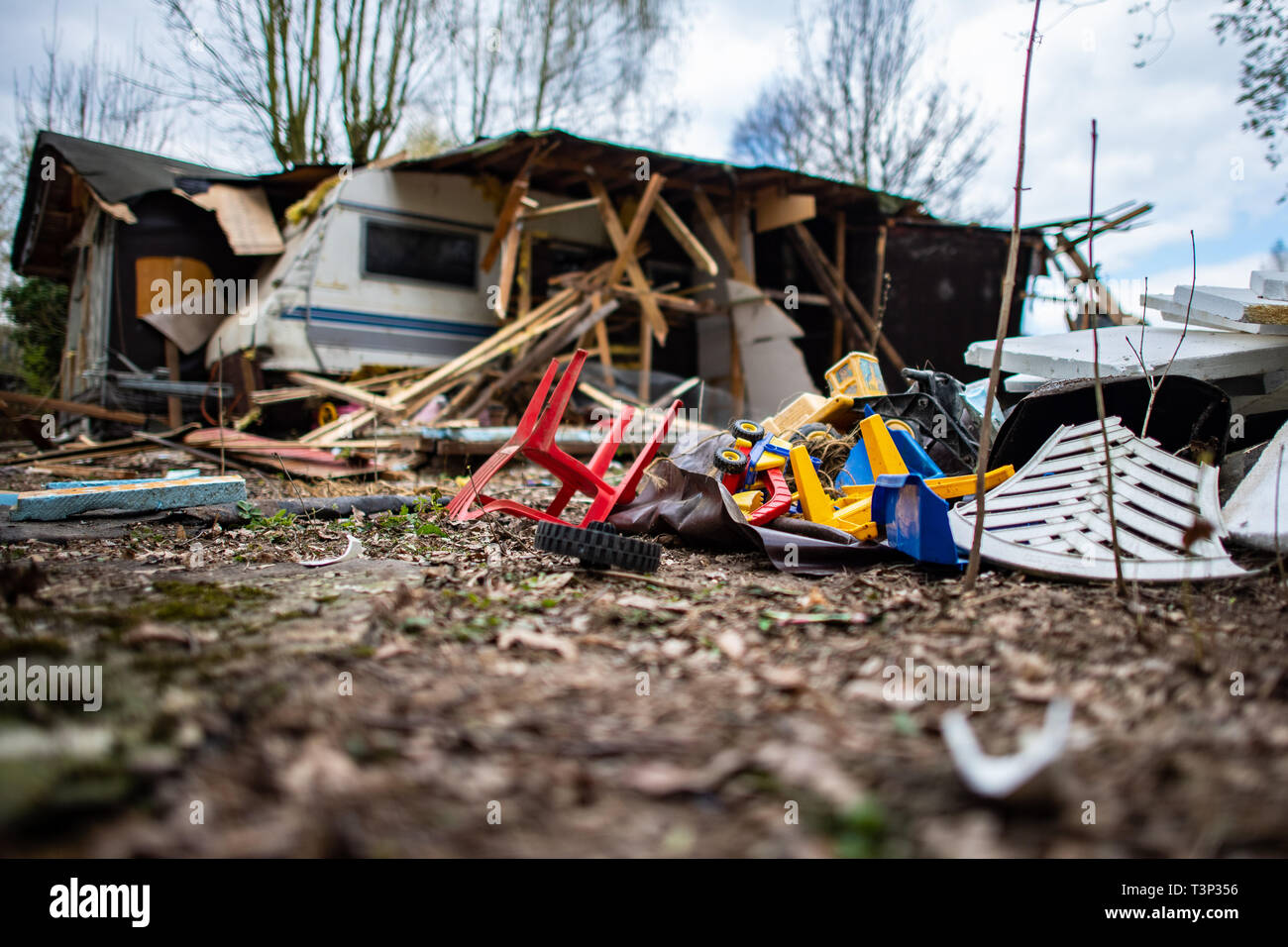 11 April 2019, North Rhine-Westphalia, Lügde: A children's chair and children's toys are lying in front of the partly demolished plot of land of the alleged perpetrator on the camping site Eichwald in the district of Elbrinxen. The campsite operator has the crime scene demolished, where several children were abused and filmed. The demolition work will continue until the weekend due to the large quantity. Photo: Guido Kirchner/dpa Stock Photo