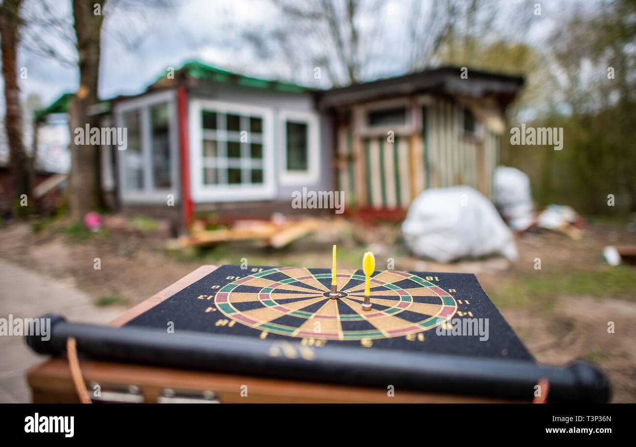 11 April 2019, North Rhine-Westphalia, Lügde: A children's darts game is located in front of the partly demolished plot of land of the alleged perpetrator on the camping site Eichwald in the district of Elbrinxen. The campsite operator has the crime scene demolished, where several children were abused and filmed. The demolition work will continue until the weekend due to the large quantity. Photo: Guido Kirchner/dpa Stock Photo