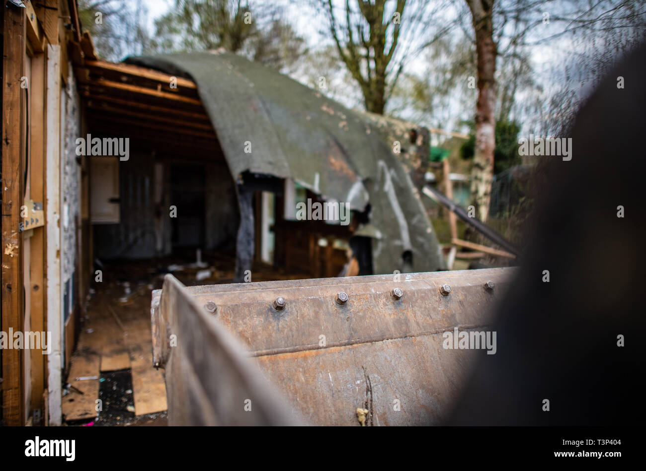 11 April 2019, North Rhine-Westphalia, Lügde: An excavator shovel stands in front of the partly demolished plot of land of the alleged perpetrator on the camping site Eichwald in the district Elbrinxen. The campsite operator has the crime scene demolished, where several children were abused and filmed. The demolition work will continue until the weekend due to the large quantity. Photo: Guido Kirchner/dpa Stock Photo