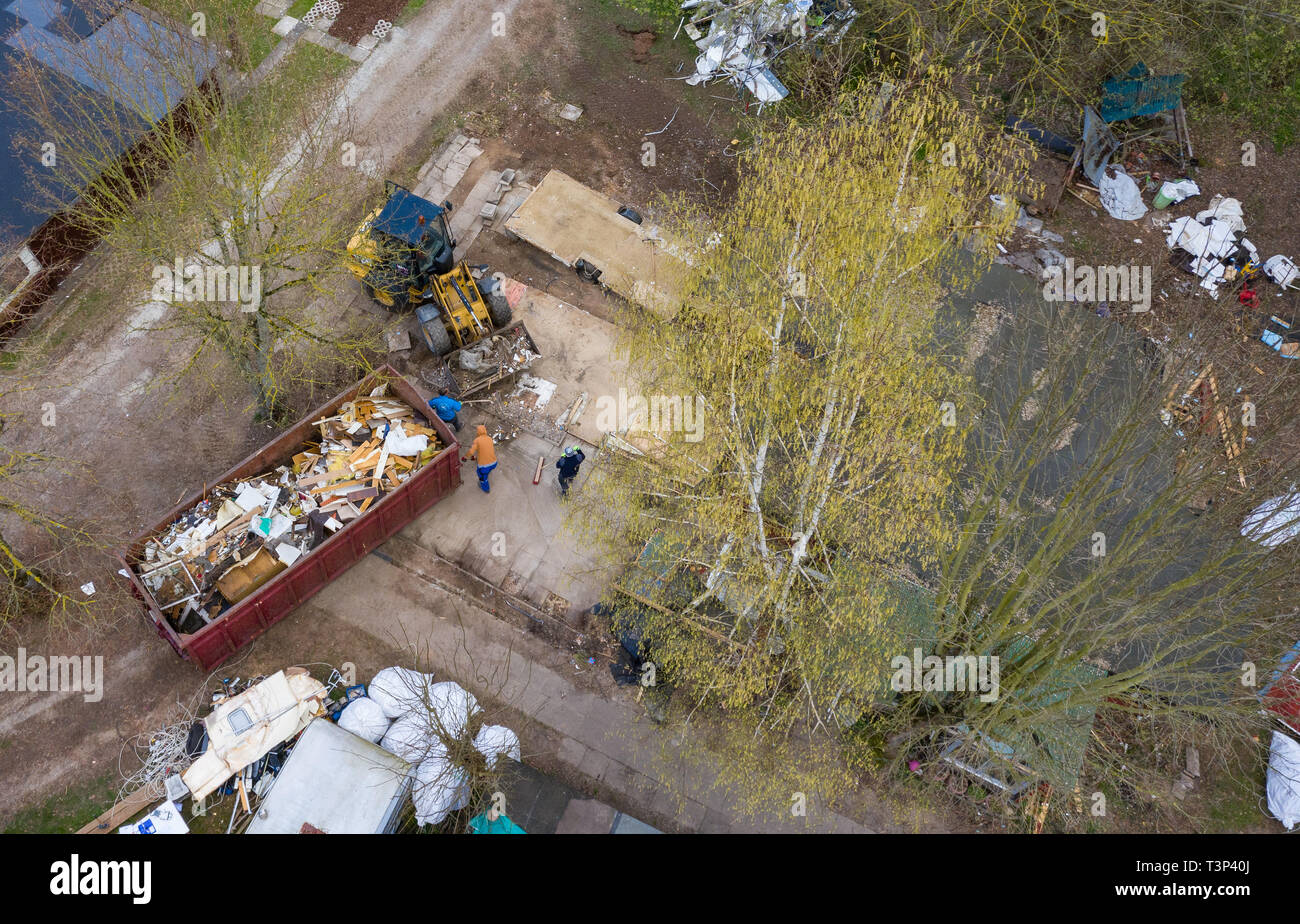 11 April 2019, North Rhine-Westphalia, Lügde: An excavator stands in front of the partly demolished plot of land of the alleged perpetrator at the camping site Eichwald in the district Elbrinxen and demolishes the complete complex. (recorded with a drone). The campsite operator has the crime scene torn down. Children had been abused on the campsite in the district of Lippe. Photo: Guido Kirchner/dpa Stock Photo