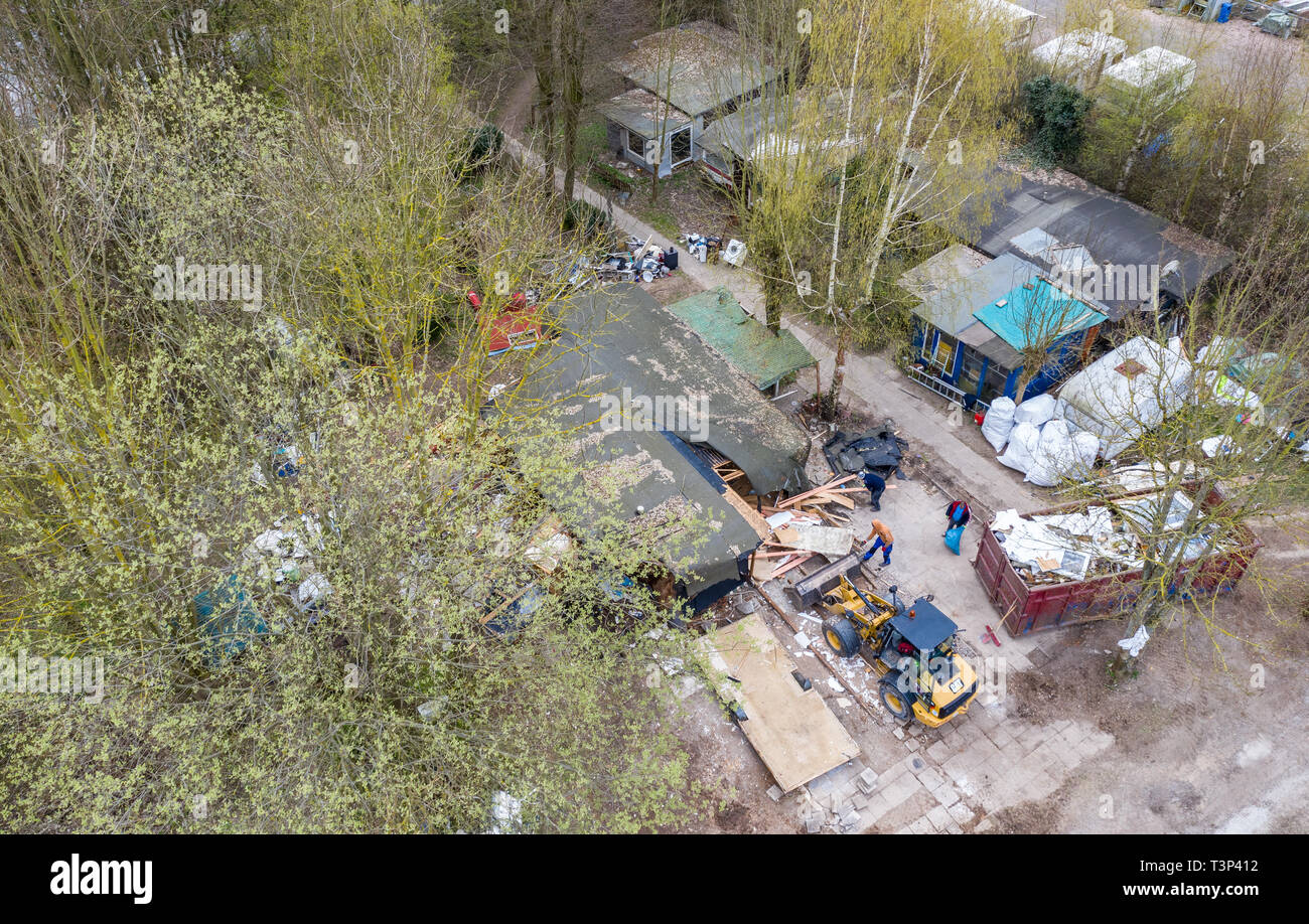 11 April 2019, North Rhine-Westphalia, Lügde: An excavator stands in front of the partly demolished plot of land of the alleged perpetrator at the camping site Eichwald in the district Elbrinxen and demolishes the complete complex (taken with a drone). The campsite operator has the crime scene demolished, where several children were abused and filmed. The demolition work will continue until the weekend due to the large quantity. Photo: Guido Kirchner/dpa Stock Photo