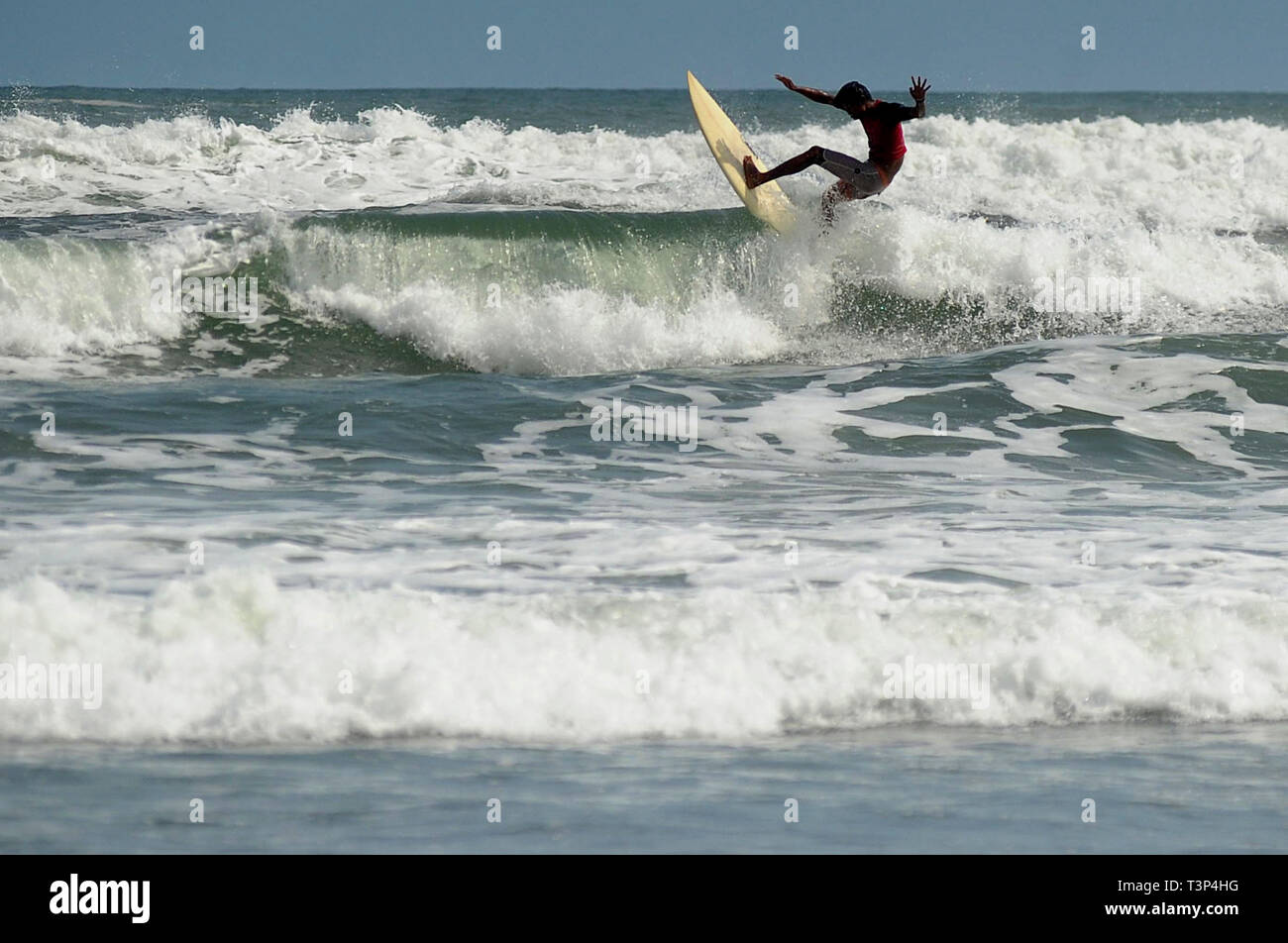 Yogyakarta, Indonesia. 11th Apr, 2019. A man goes surfing at Parangtritis beach in Yogyakarta, Indonesia, April 11, 2019. Credit: Supriyanto/Xinhua/Alamy Live News Stock Photo