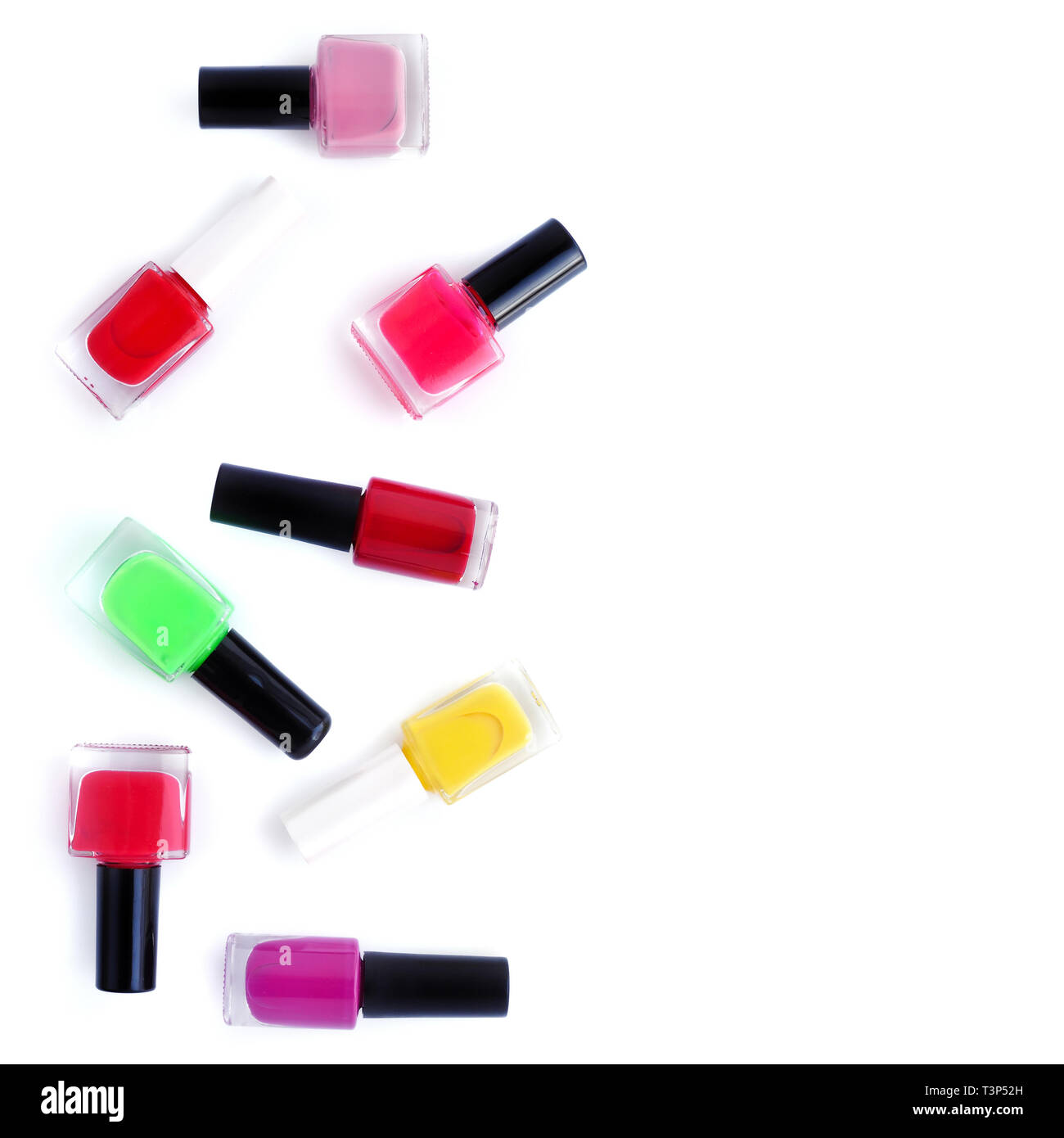 Coloured nail polish bottles on white background with copy space. Top view Stock Photo