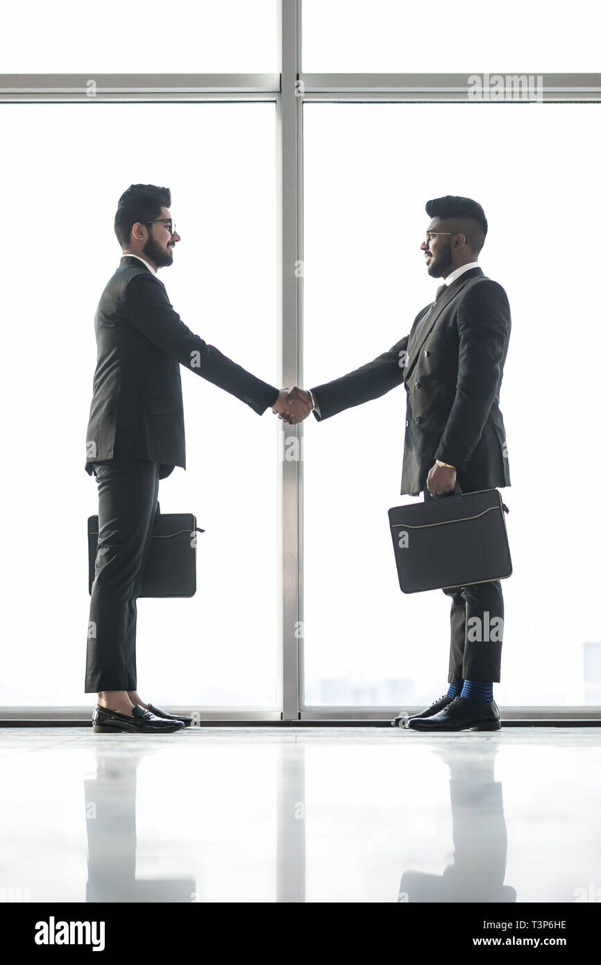 Full length side view of businessmen shaking hands in office Stock ...