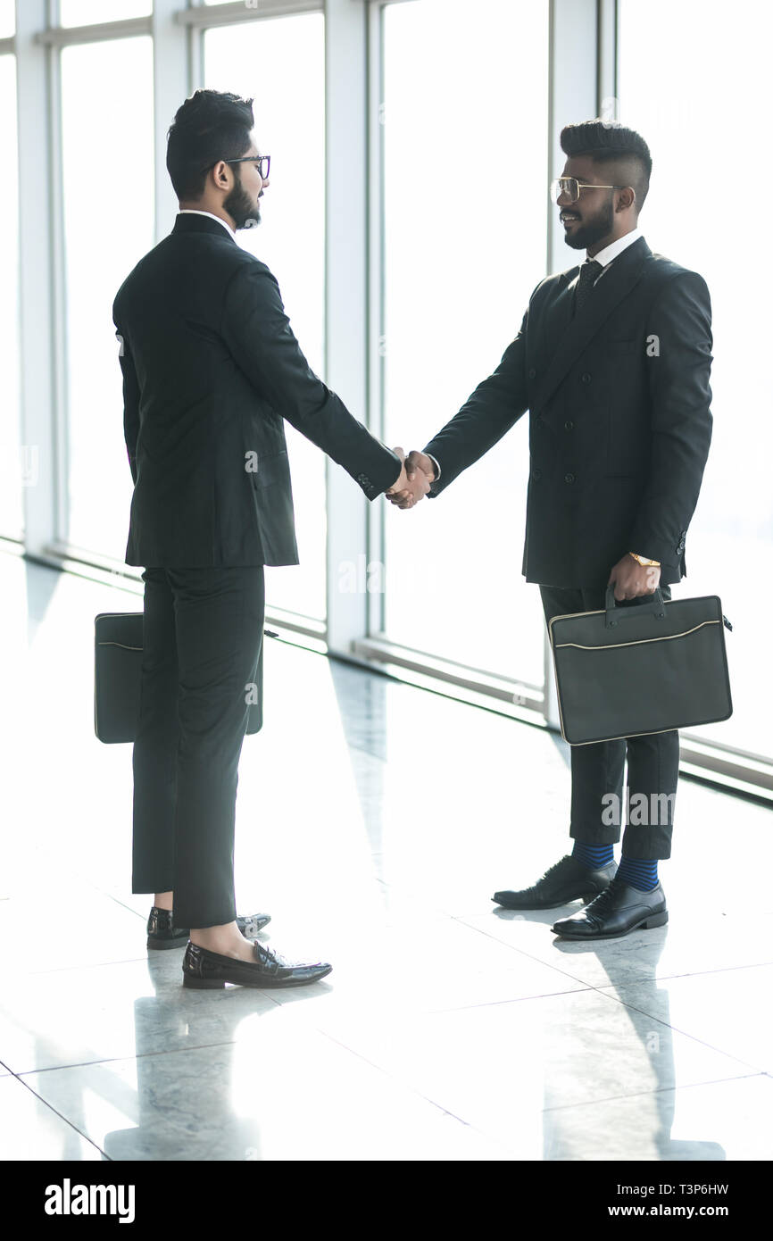 Full length side view of businessmen shaking hands in office Stock ...
